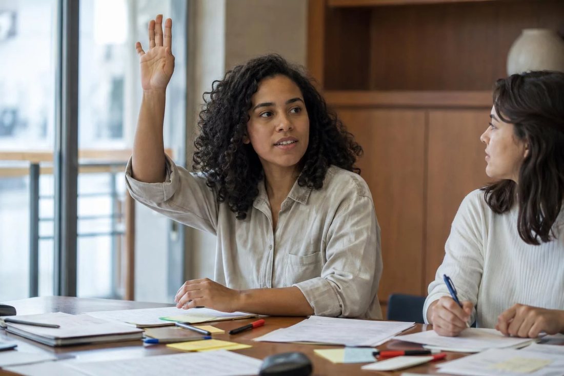 Facilitador de pé apontando para um argumento escrito no quadro durante a sessão
